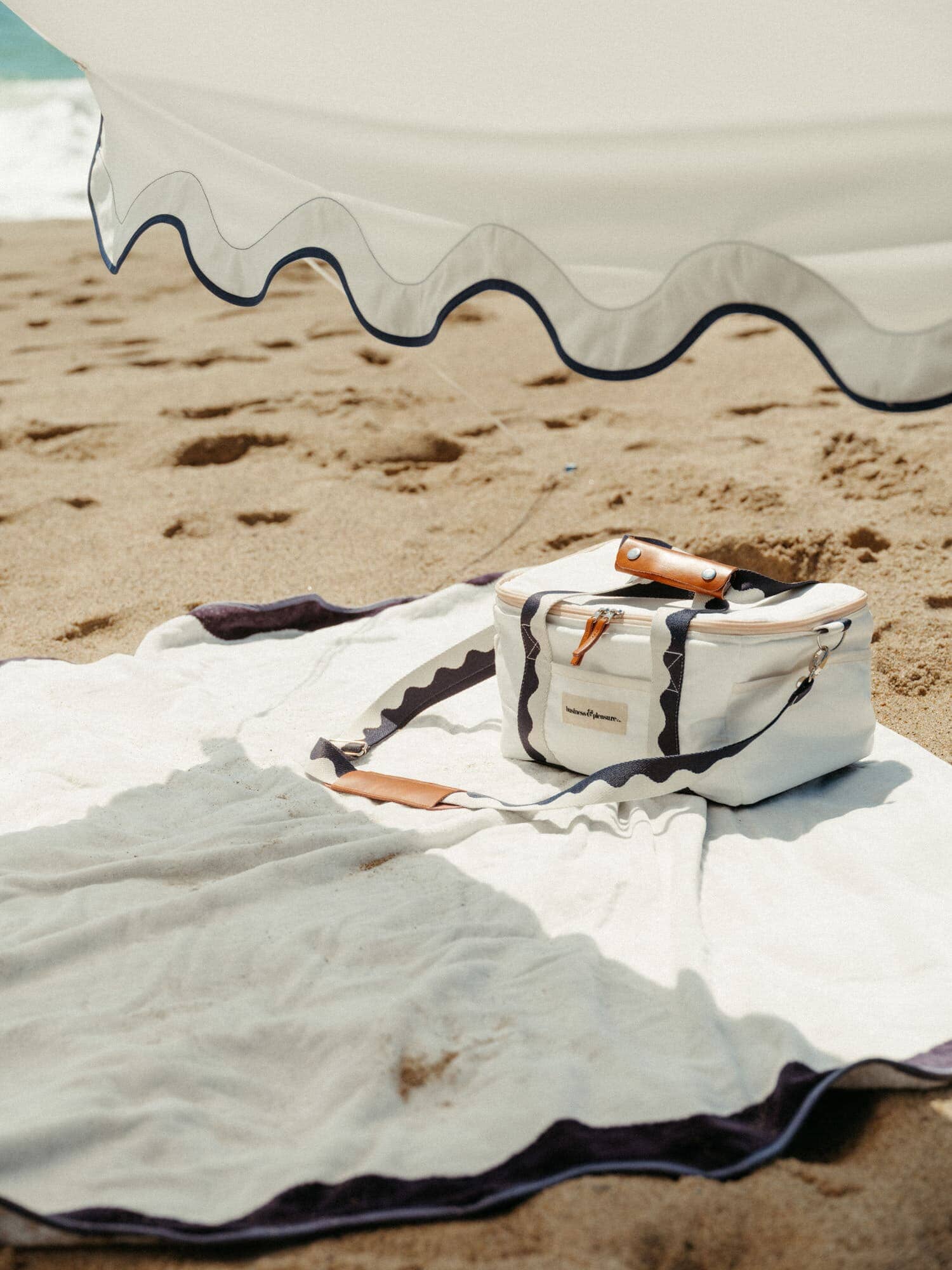 white riviera blanket and cooler on a beach