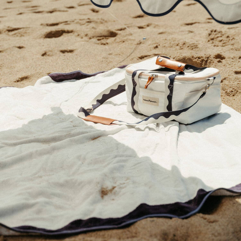 white riviera blanket and cooler on a beach