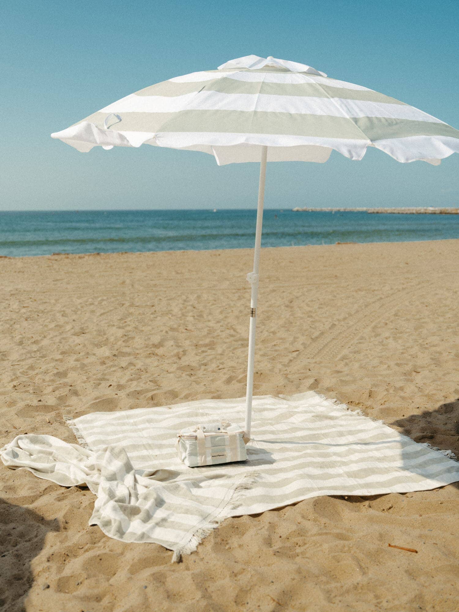 Sage umbrella, towel and cooler on the beach