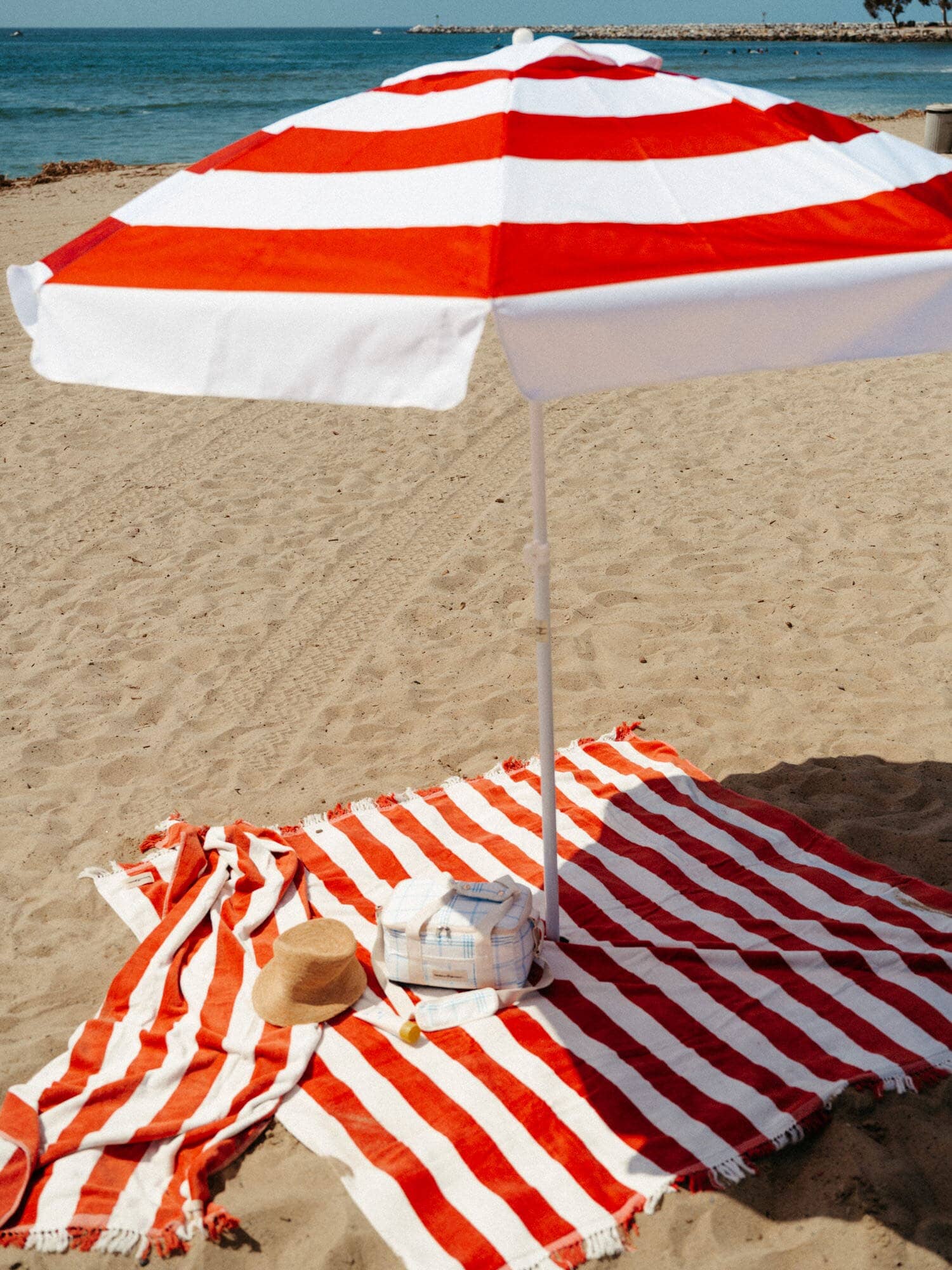 Le sirenuse holiday beach set up with umbrella, blanket, towel and cooler