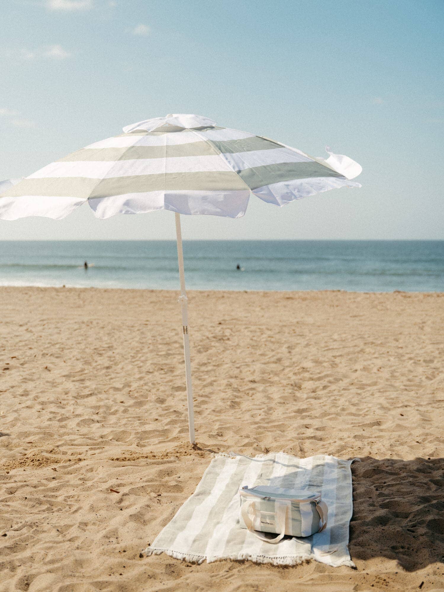 Sage holiday towel, umbrella and cooler on the beach