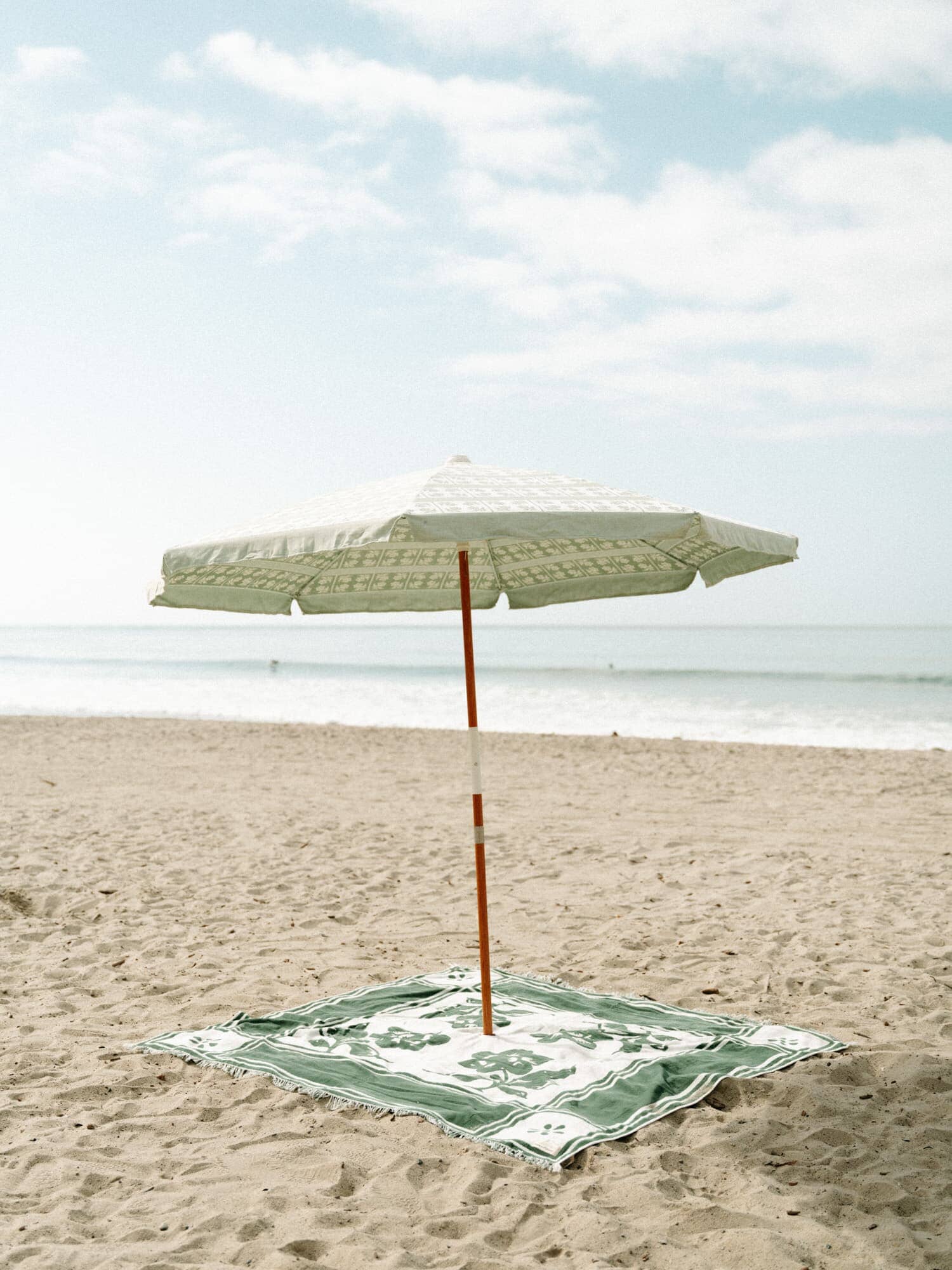 Beach setting with umbrella and blanket