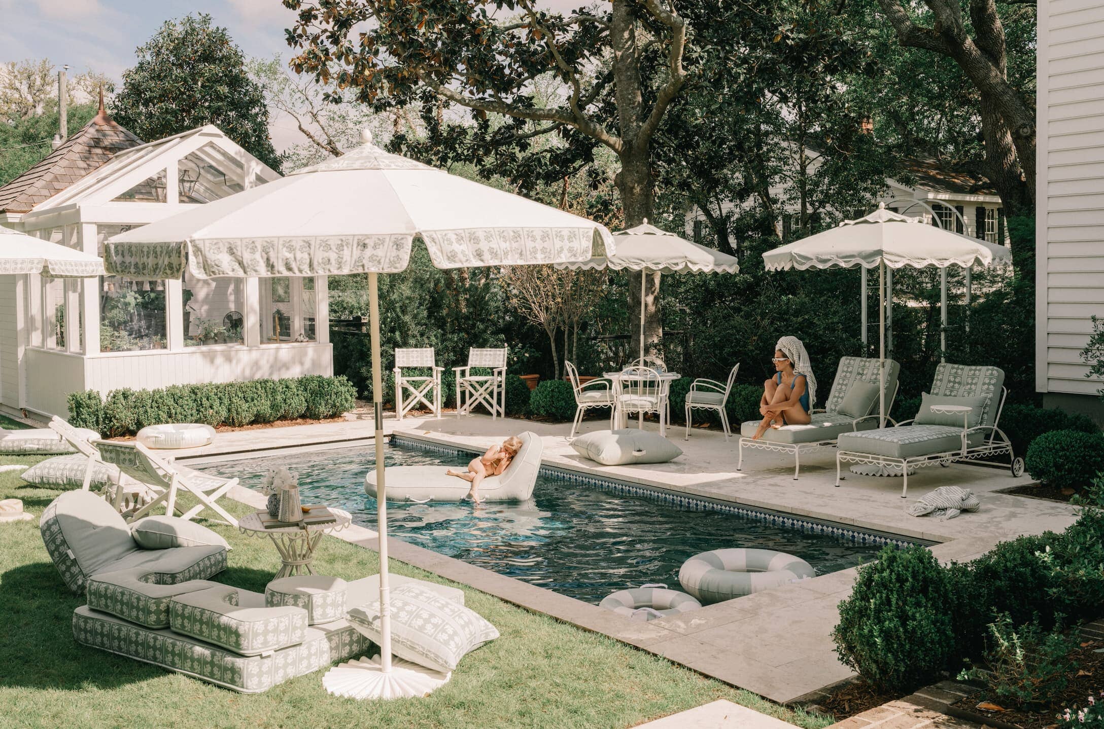 Outdoor pool area with umbrellas, chairs and outdoor cushions