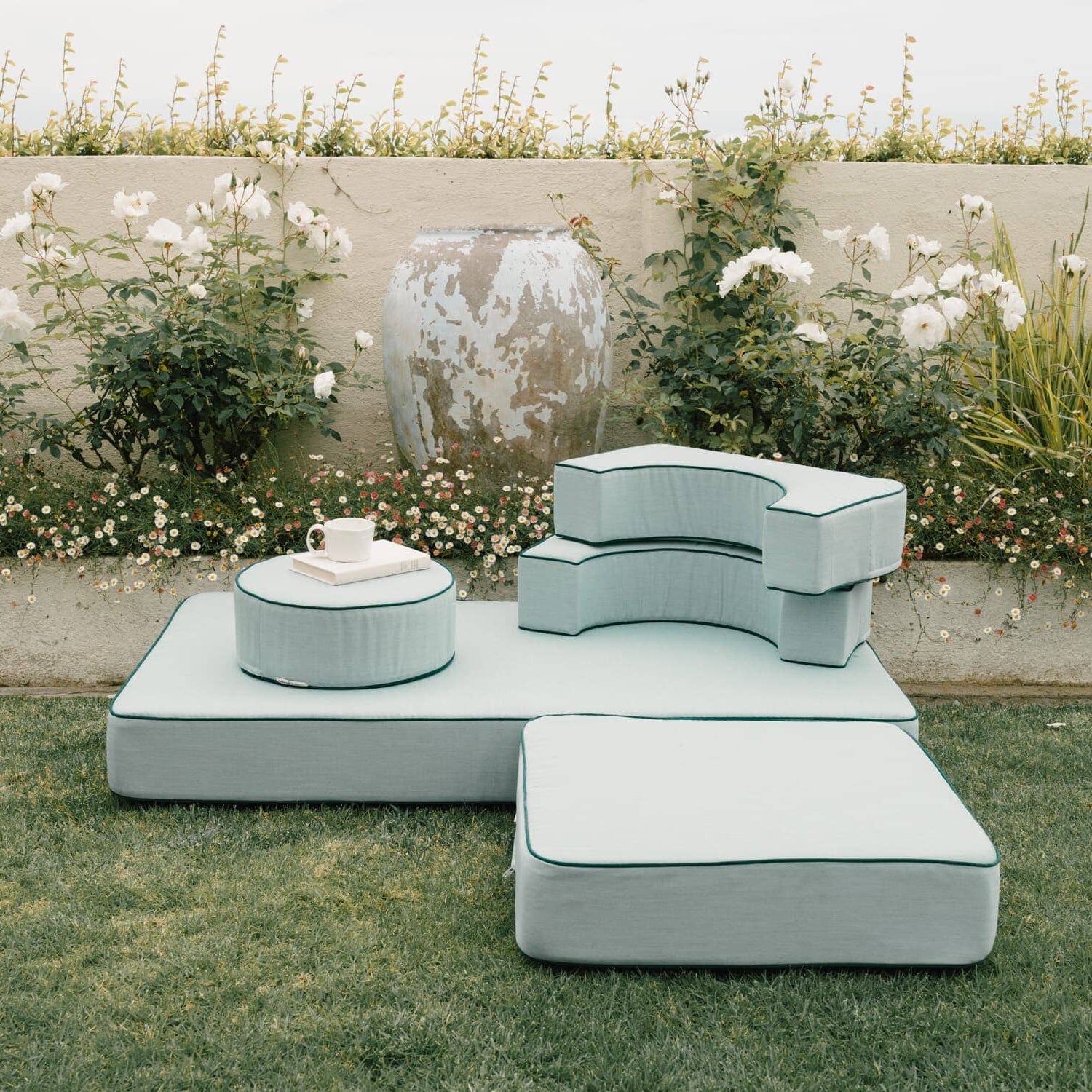 Riviera green modular pillow stack in a garden setting