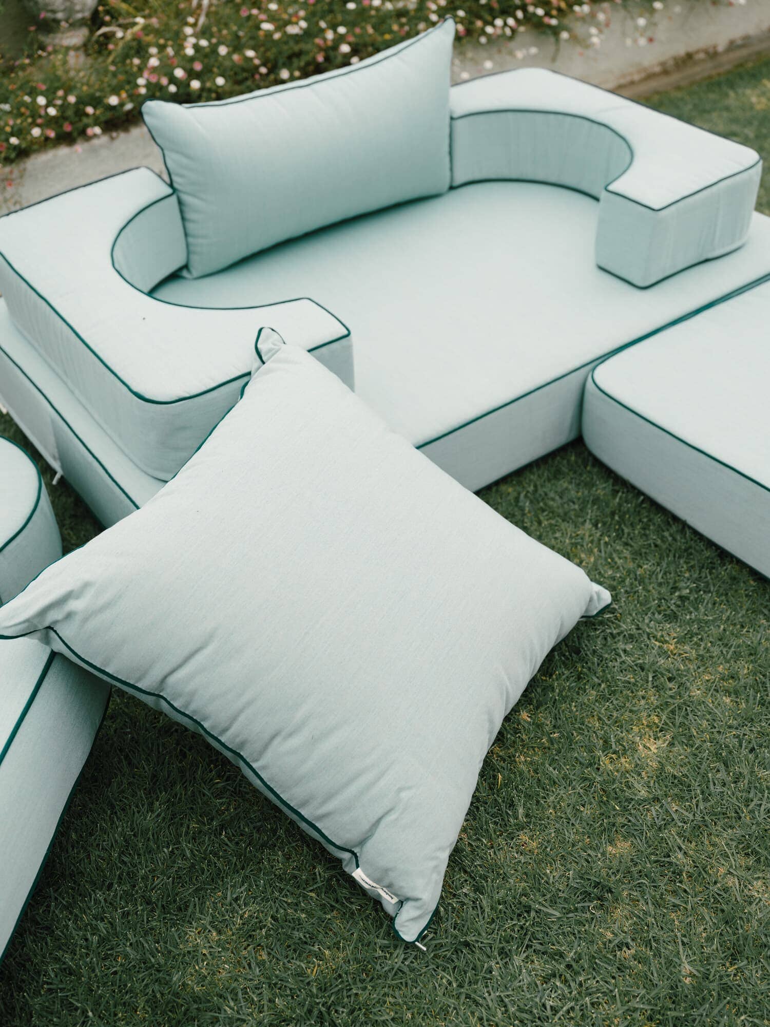 Riviera green modular pillow stack in a garden setting