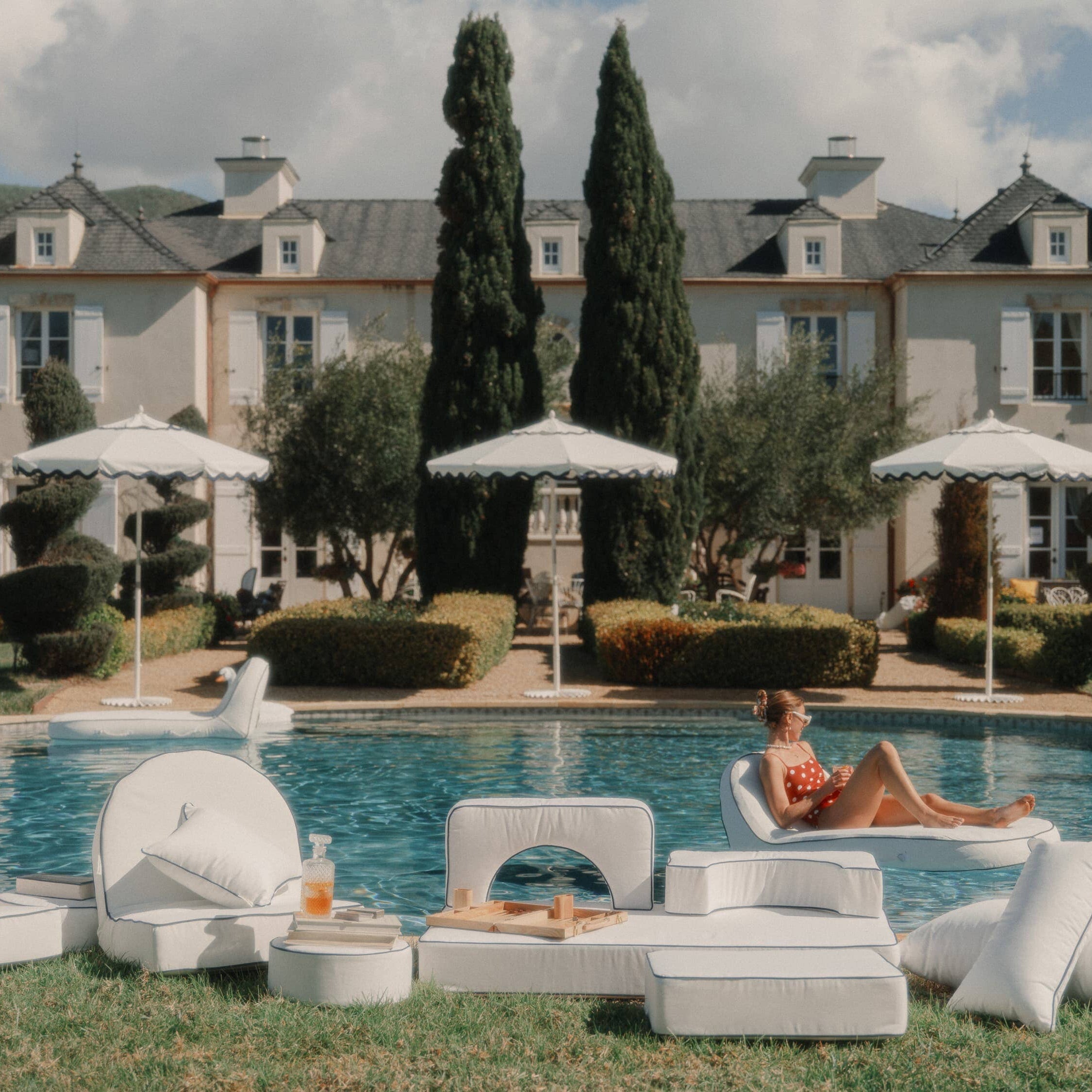 white modular cushions next to a pool