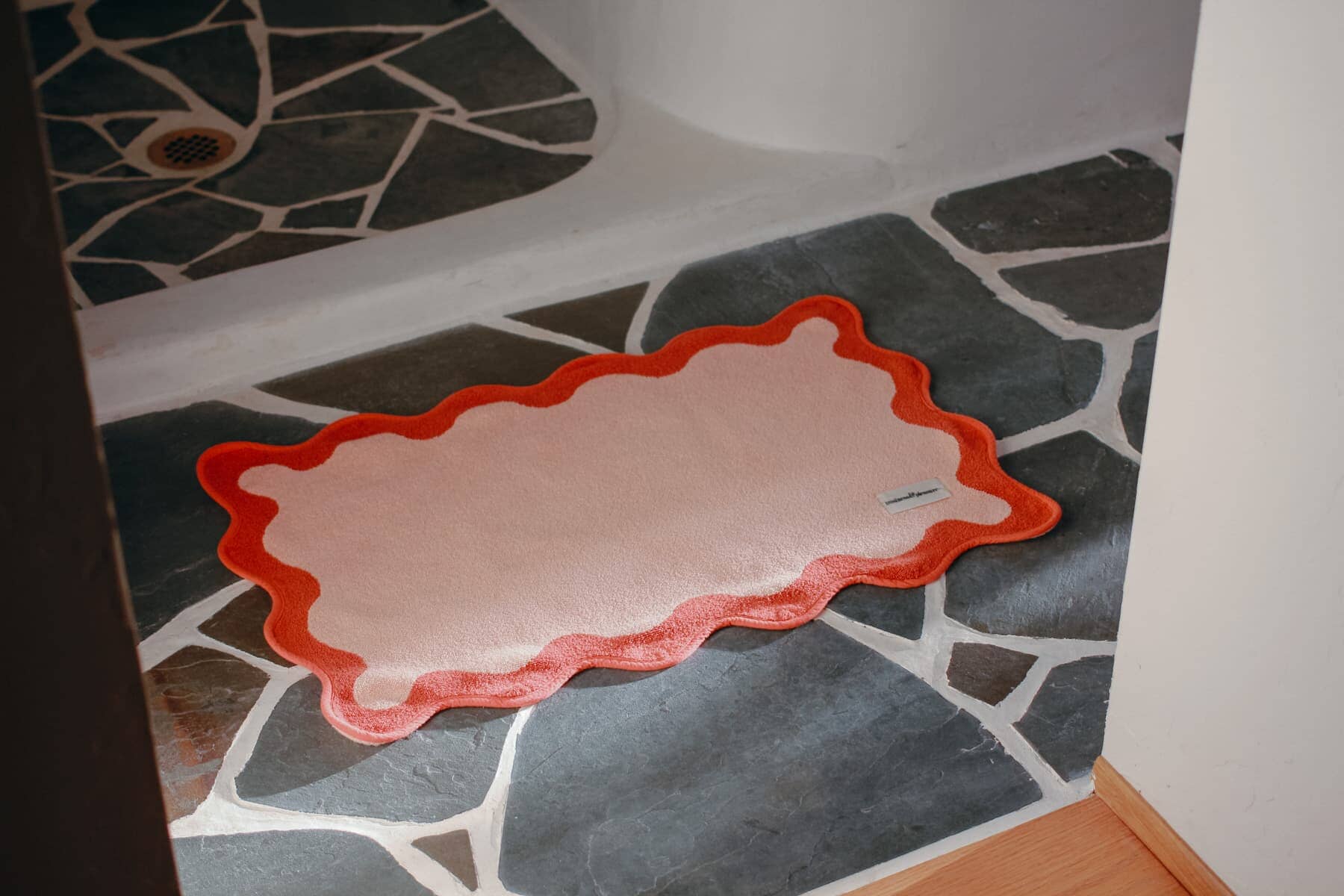 Pink bath mat on a stone floor
