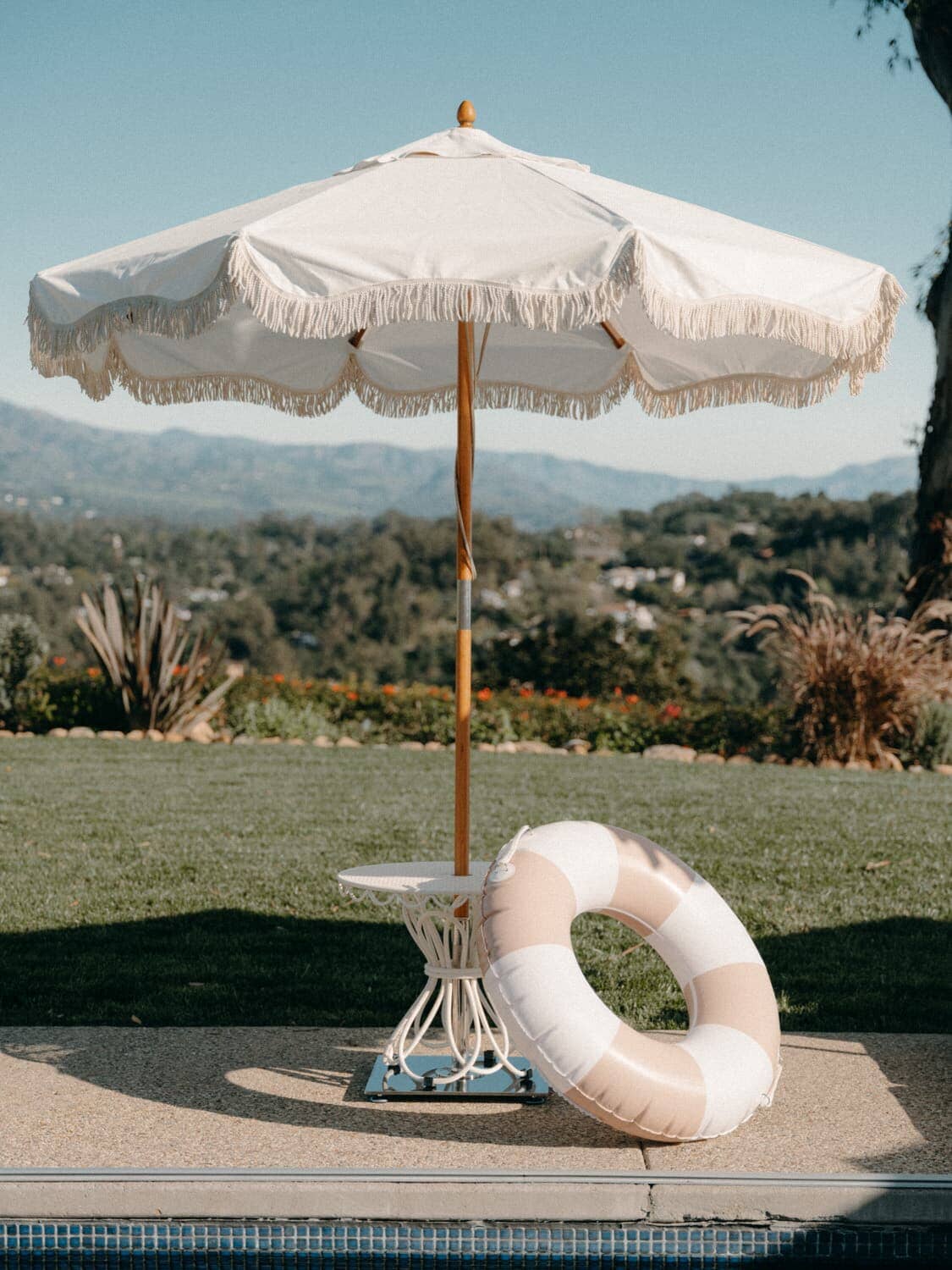 pink pool ring leaning against outdoor umbrella