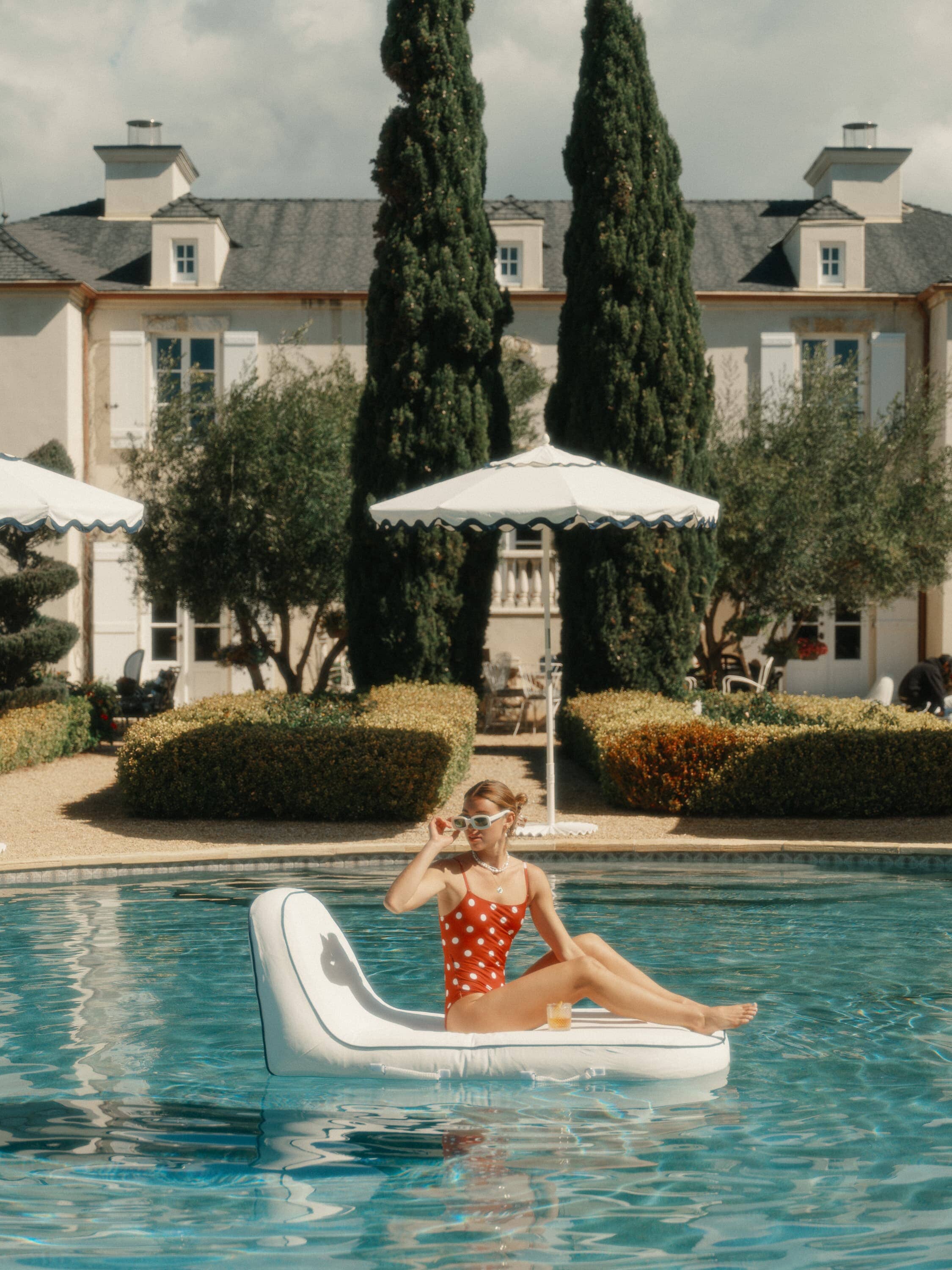 girl floating on a white pool lounger in the pool