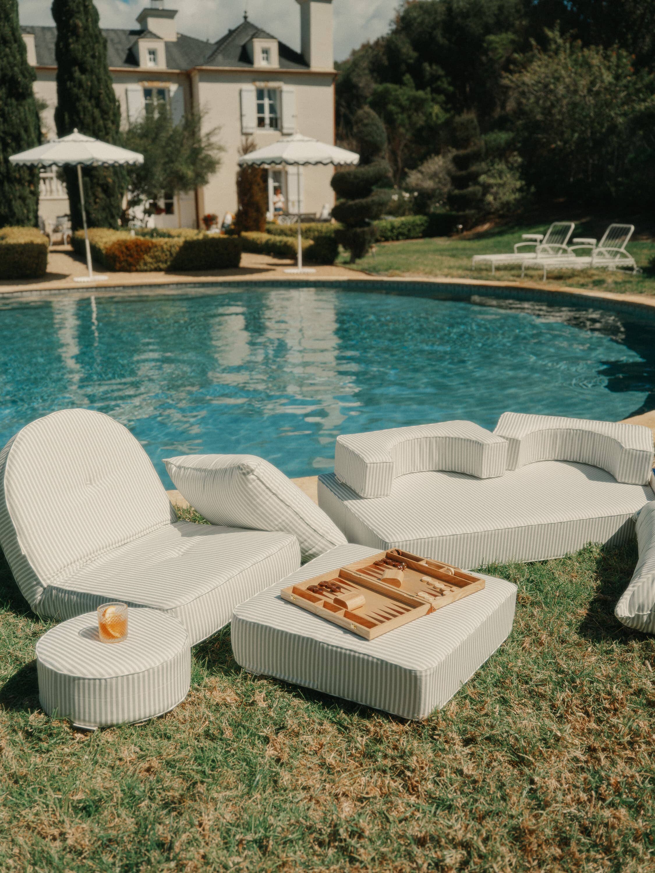 poolside set up with sage outdoor cushions and reclining lounger