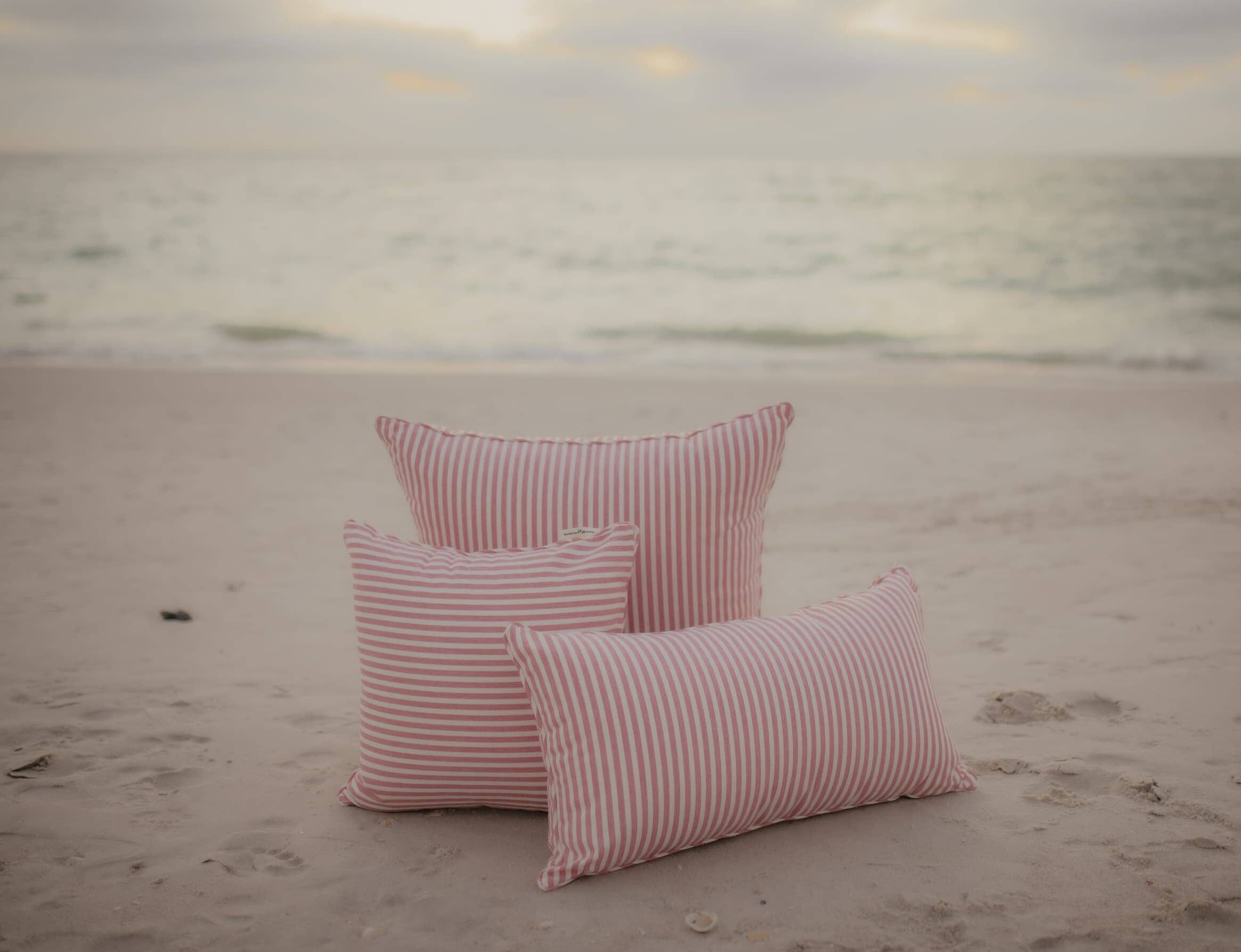 pink throw pillows on the beach