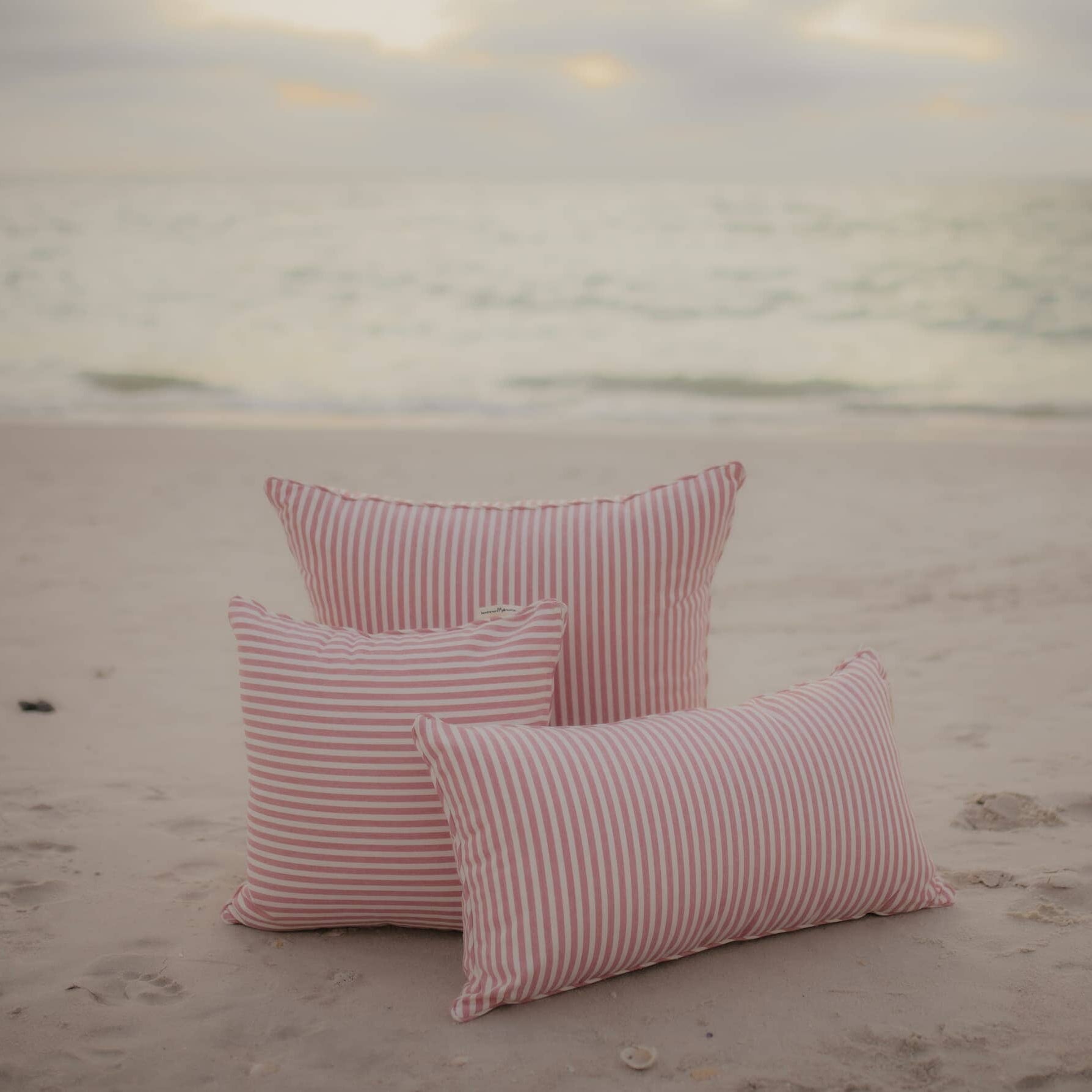 pink throw pillows on the beach