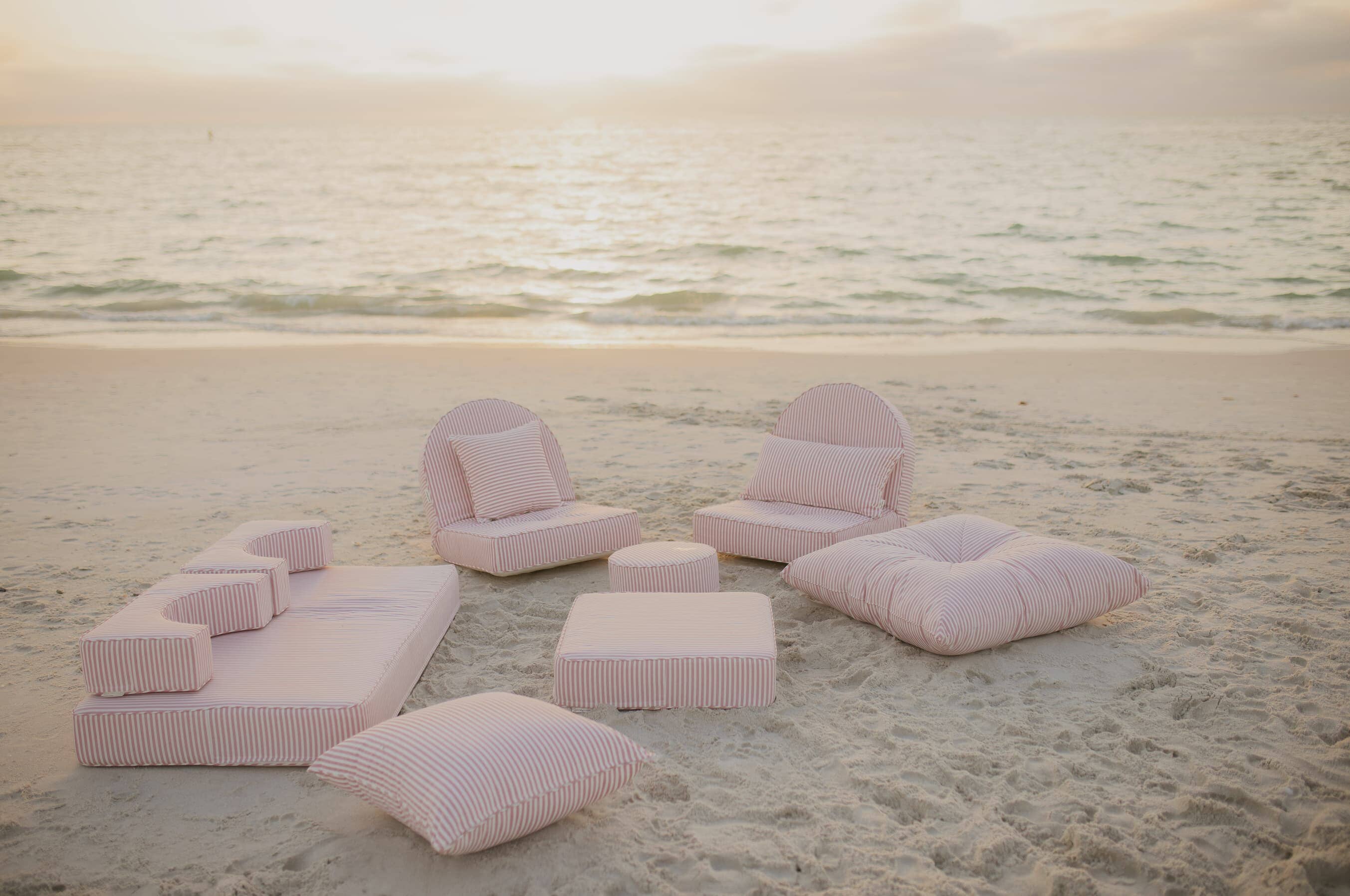 pink throw pillows and cushions on the beach