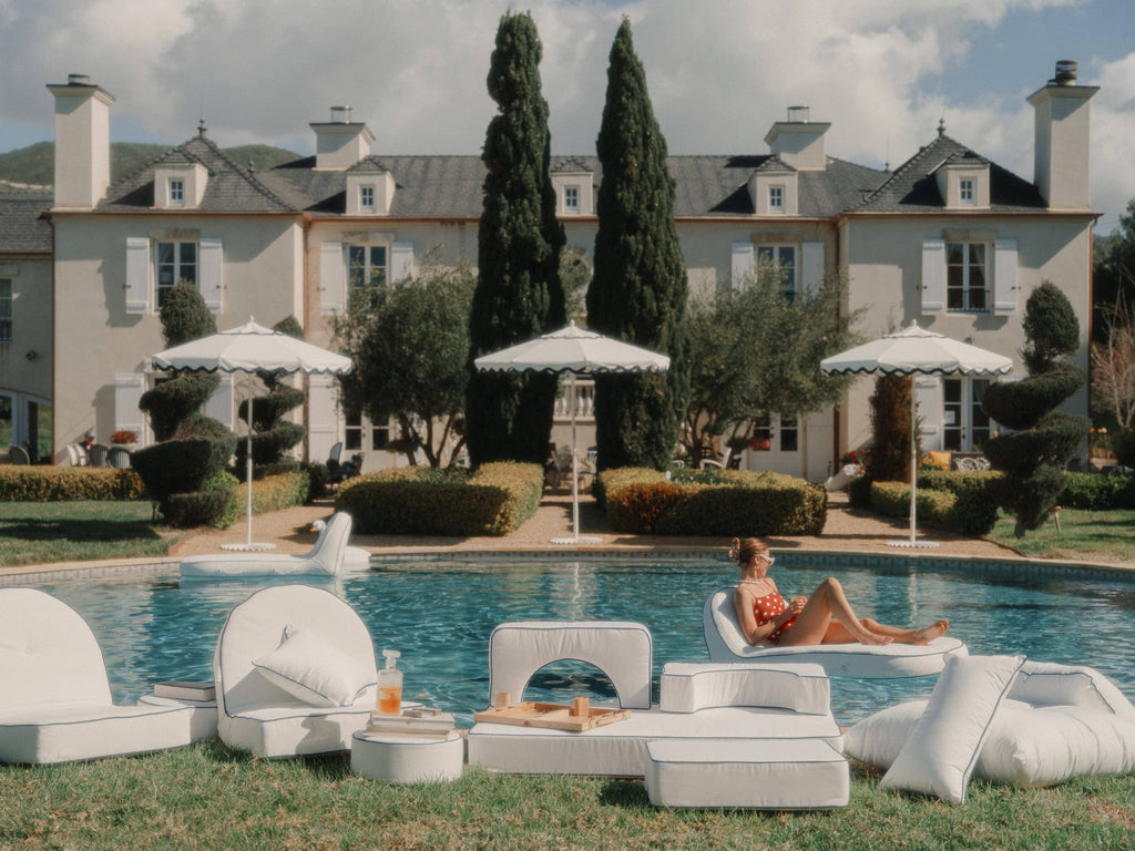 poolside set up with white pillows and cushions