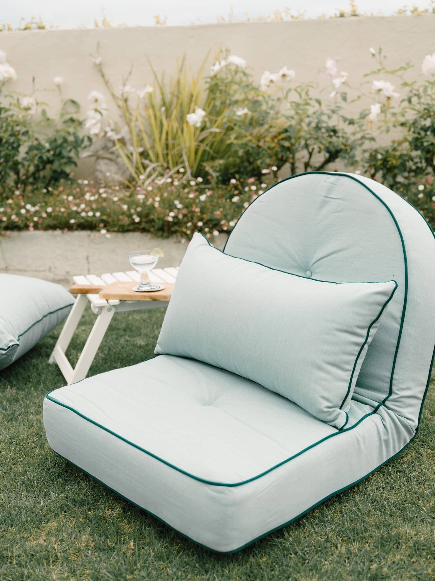 Throw pillow on reclining pillow lounger in a garden setting