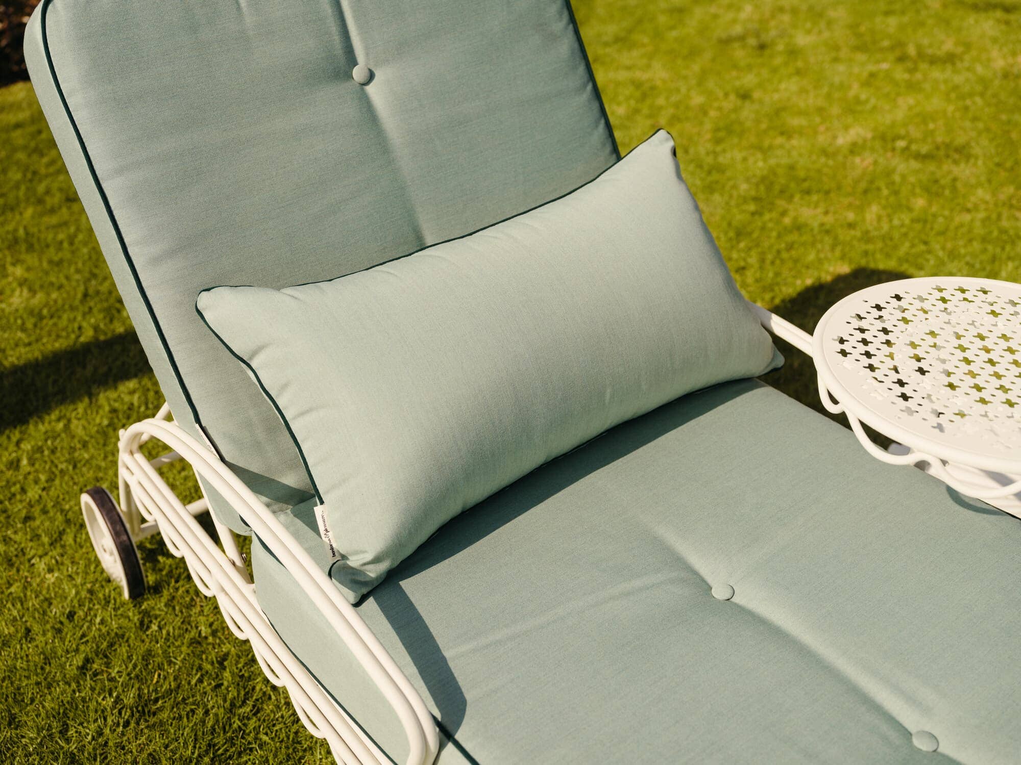 Throw pillow on reclining sun lounger in a garden setting