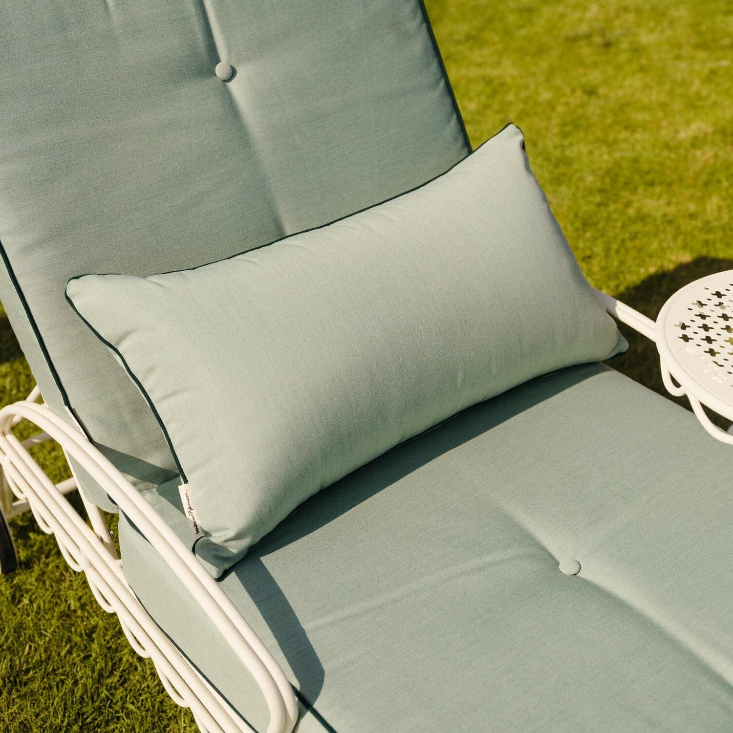 Throw pillow on reclining sun lounger in a garden setting