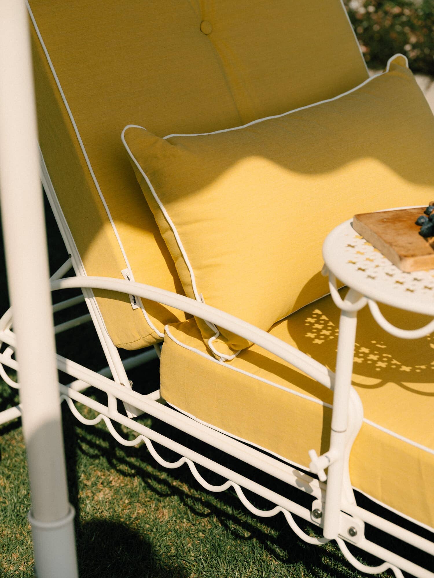 Riviera mimosa throe pillow on a sun lounger in a garden setting