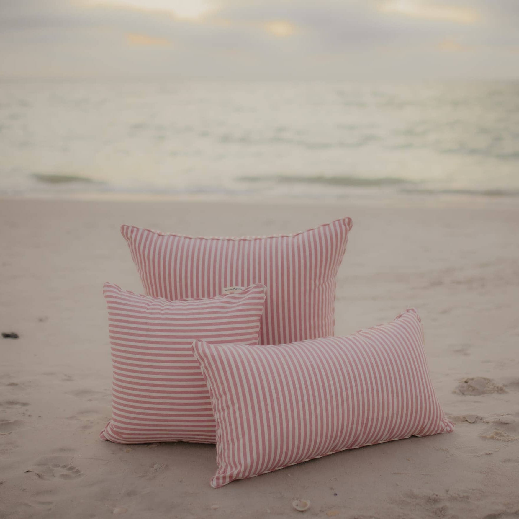 pink throw pillows on the beach