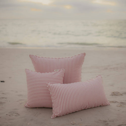 pink throw pillows on the beach