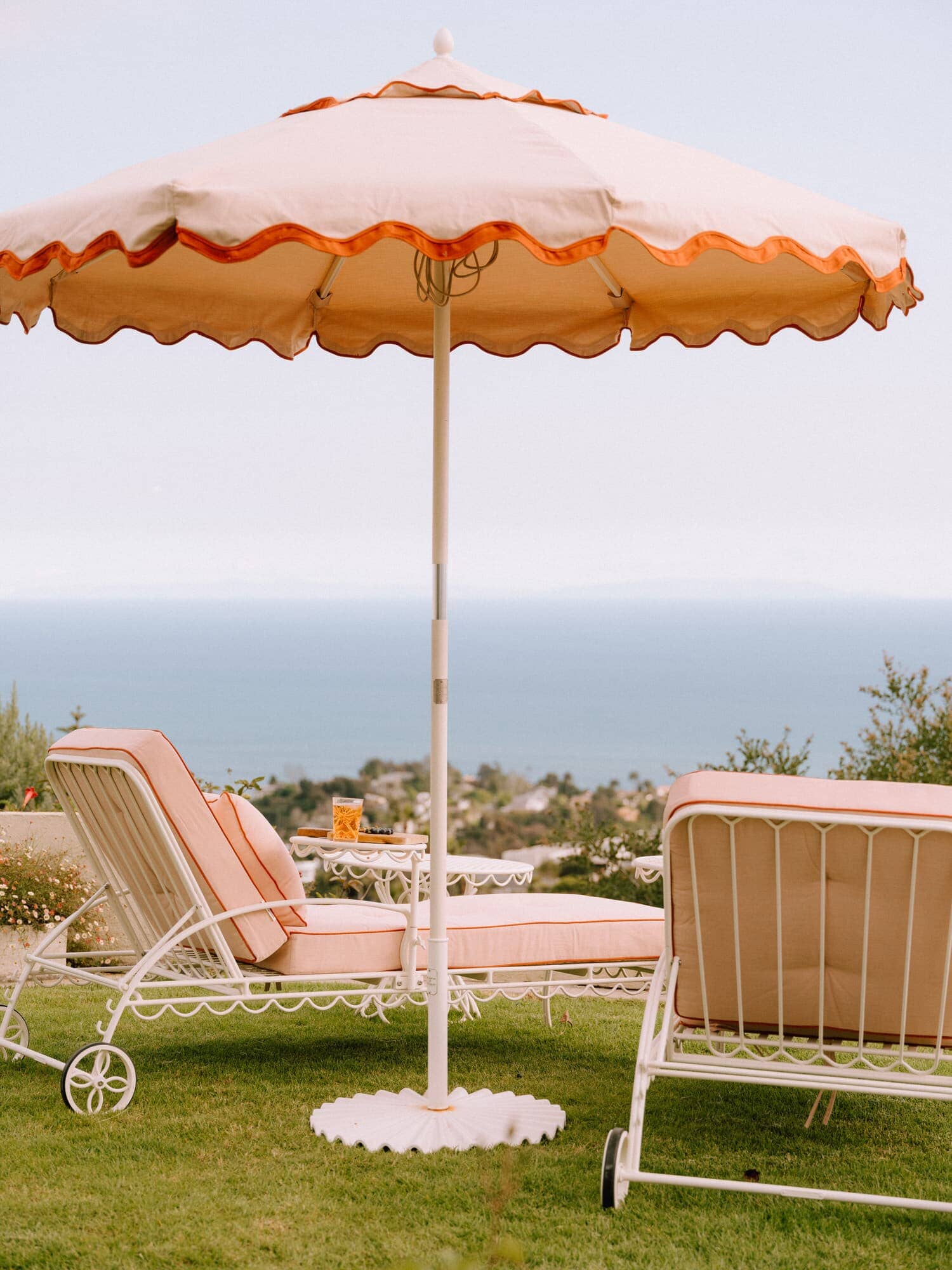 Riviera pink sun loungers with umbrella on the grass