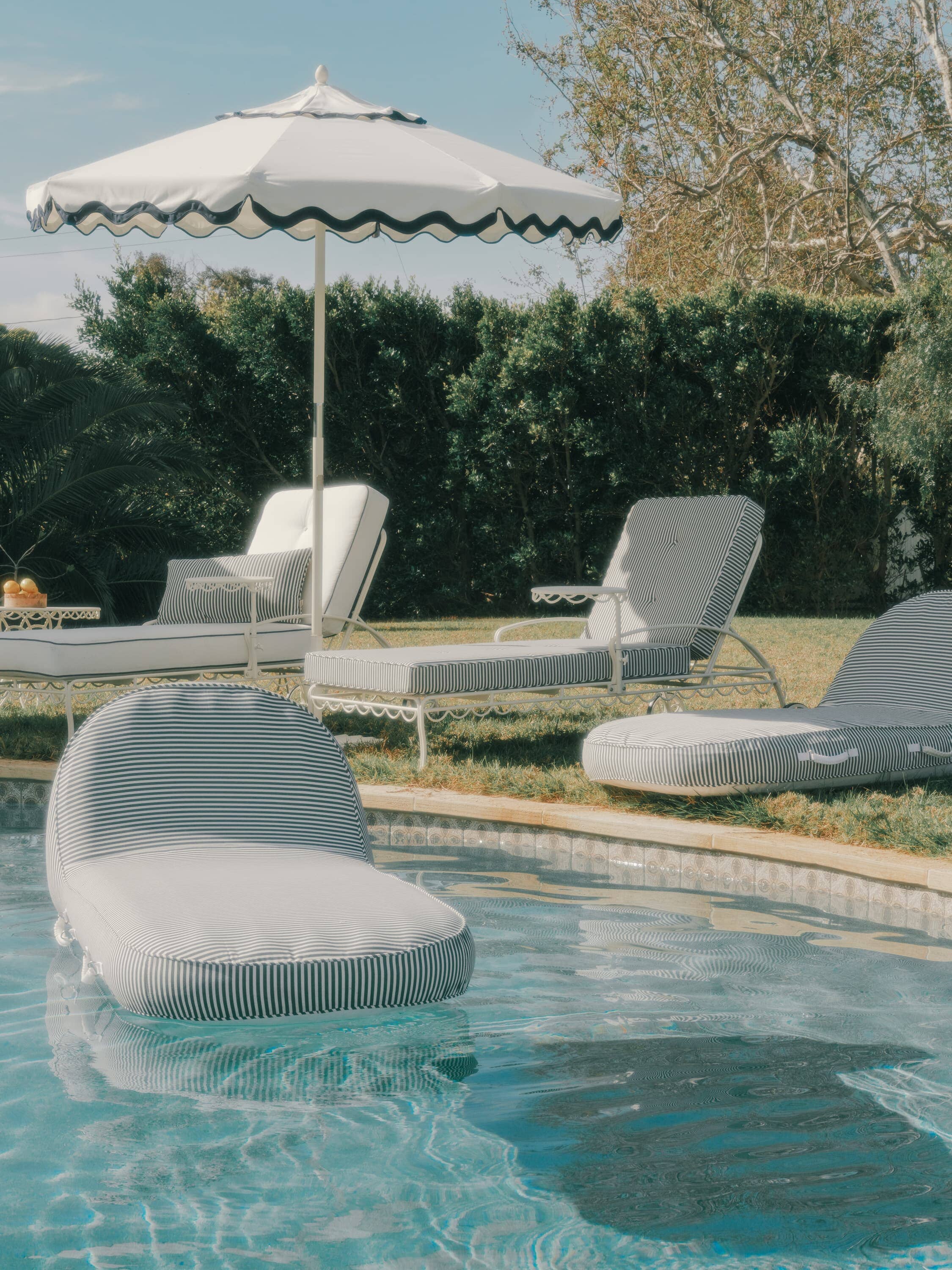 Navy and white sun loungers, navy pool loungers around a pool