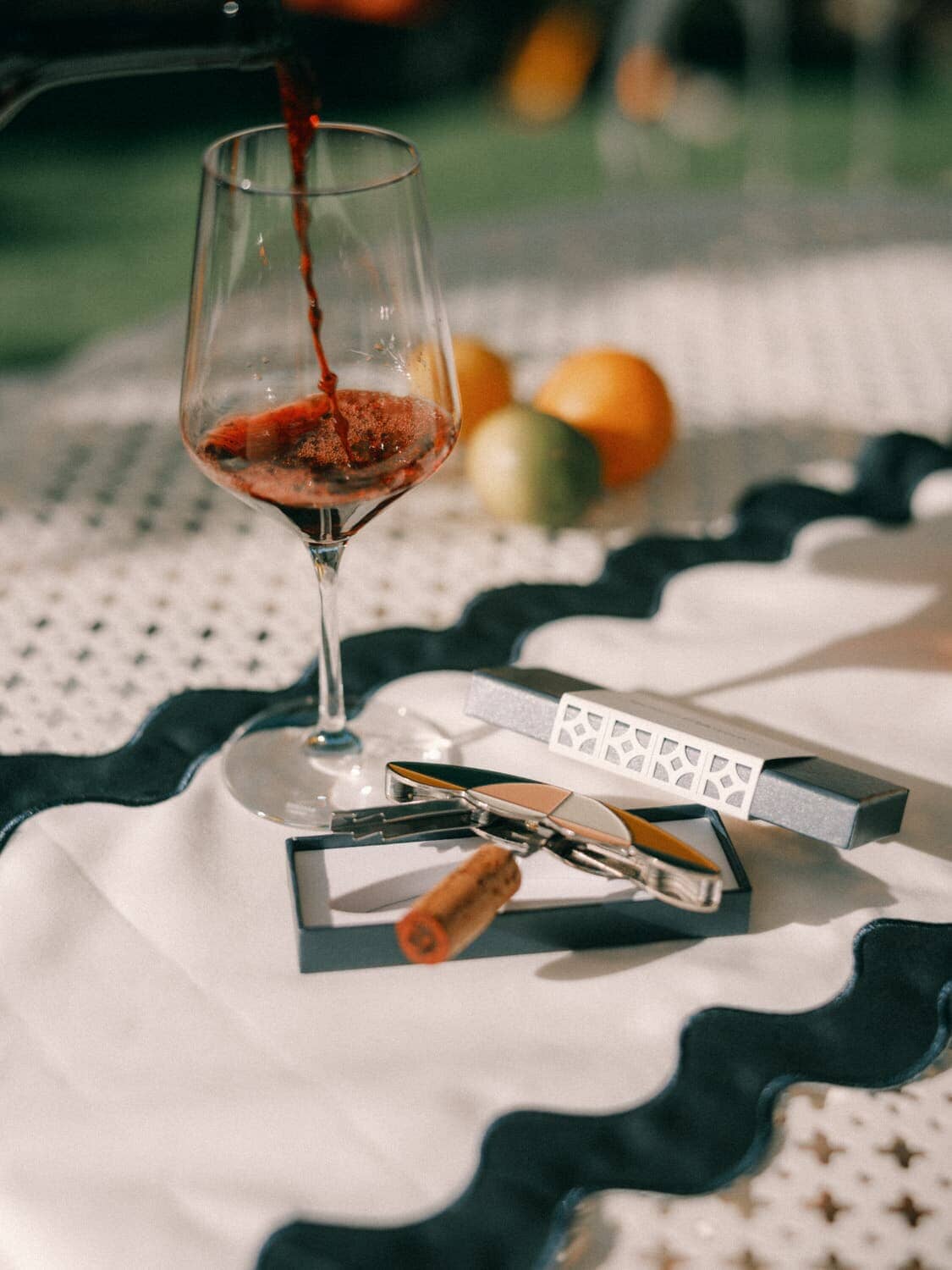 outdoor table with white table runner and glass of wine