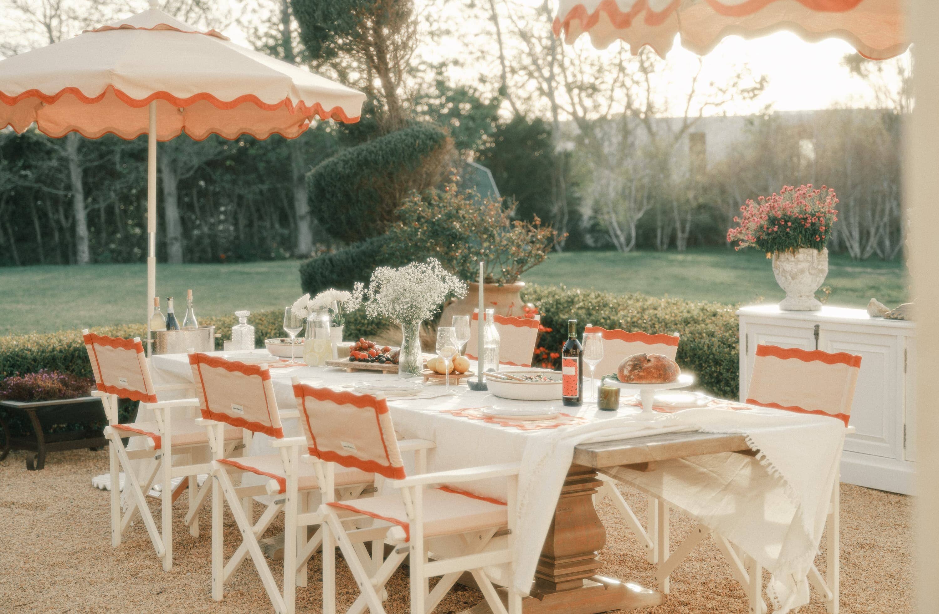 outdoor table setting with white table cloth and pink chairs & accessories
