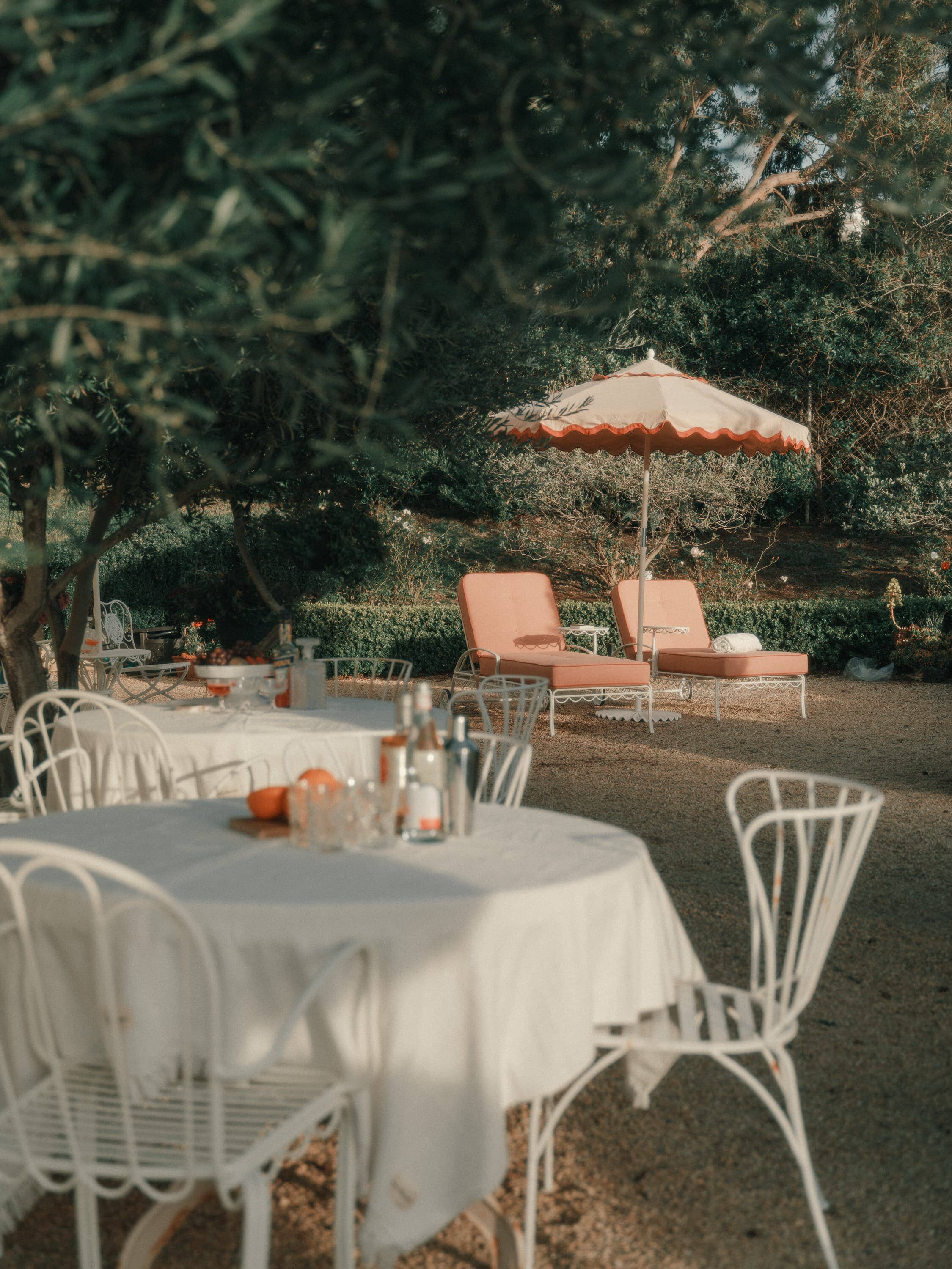 outdoor table setting with white table cloth and pink chairs & accessories