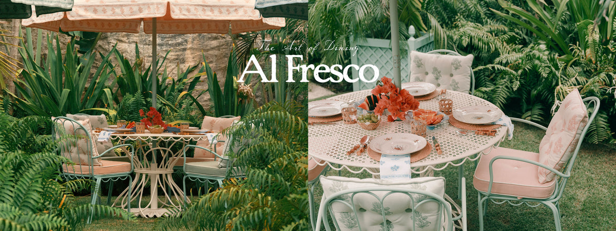 A split-screen lifestyle photograph showcasing a set of elegant outdoor patio furniture in a lush garden setting. The left side shows a round metal table and matching chairs under a striped umbrella, while the right side shows a larger dining table set with plates, glasses, and orange flowers.