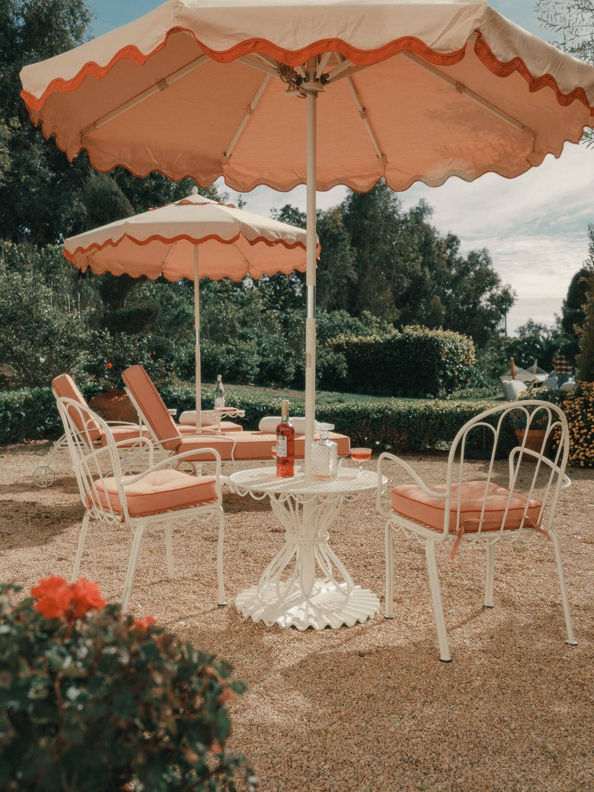 Side table with chairs and pink umbrellas in an outdoor courtyard