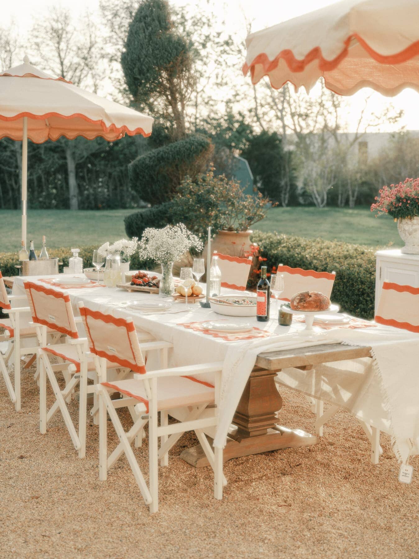 al fresco dining table with riviera pink directors chairs and market umbrellas
