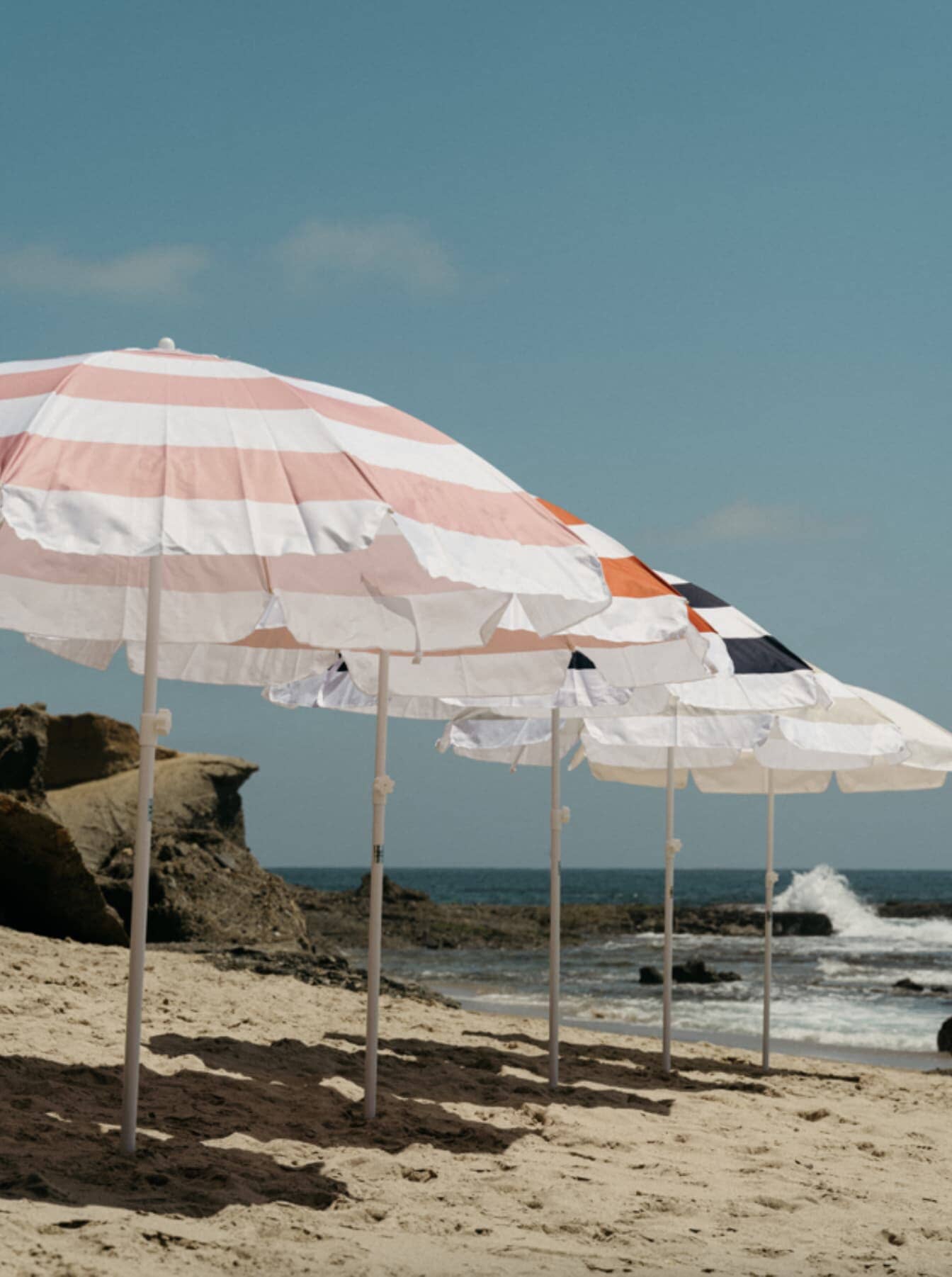 5 family umbrellas lined up on the beach