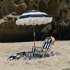 navy holiday beach umbrella on the beach with beach chair and towel