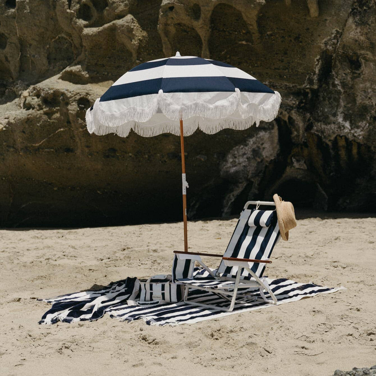 navy holiday beach umbrella on the beach with beach chair and towel