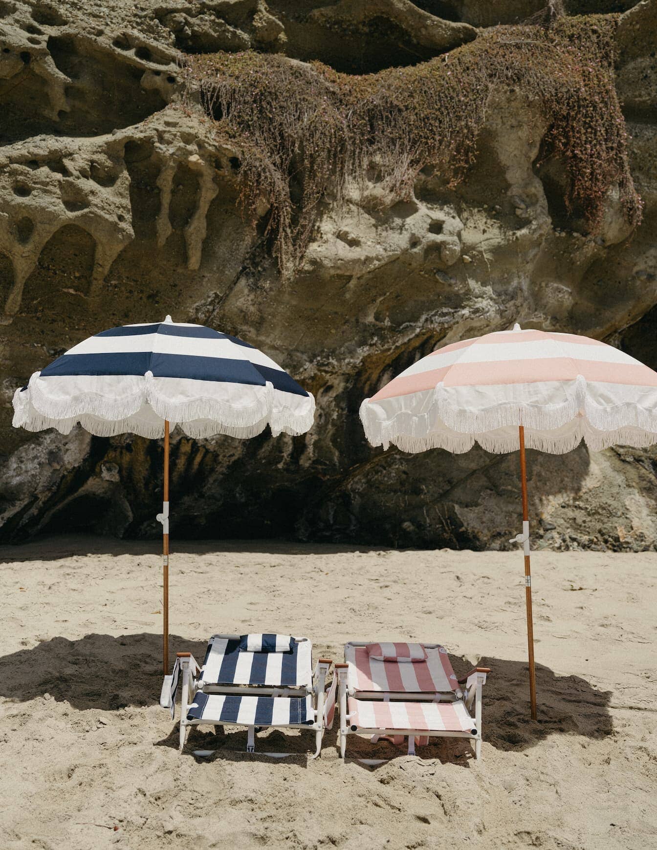 navy and pink holiday tommy chairs and umbrellas on a beach