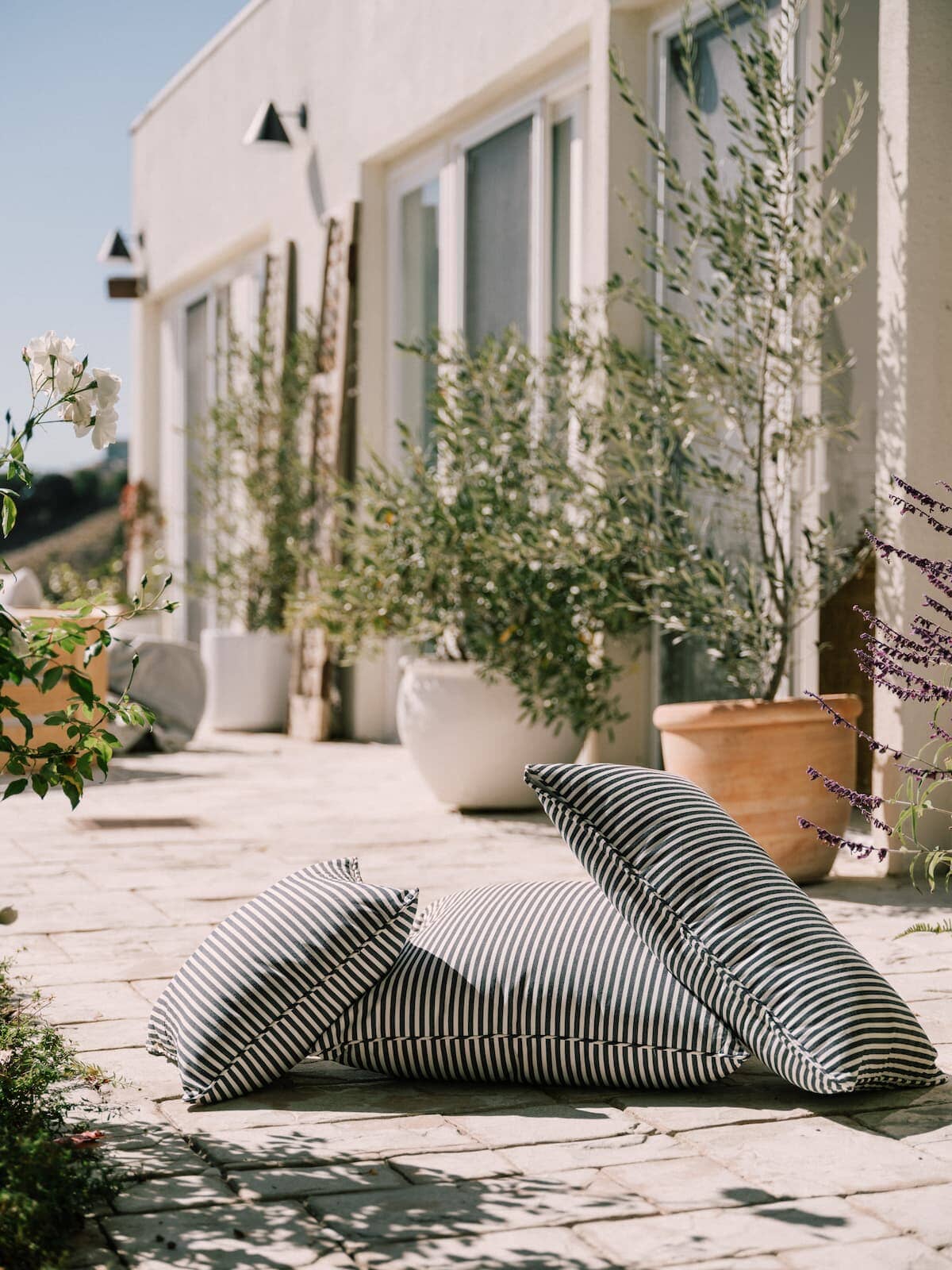 3 outdoor cushions resting on the ground on a patio