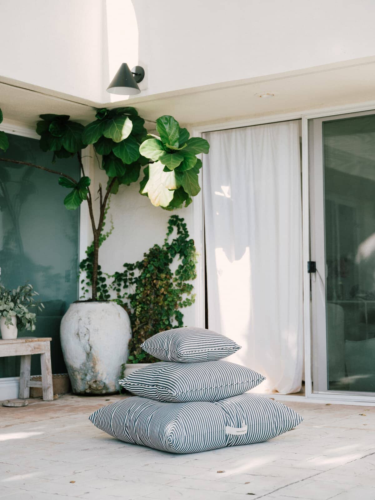 3 outdoor cushions stacked on a patio