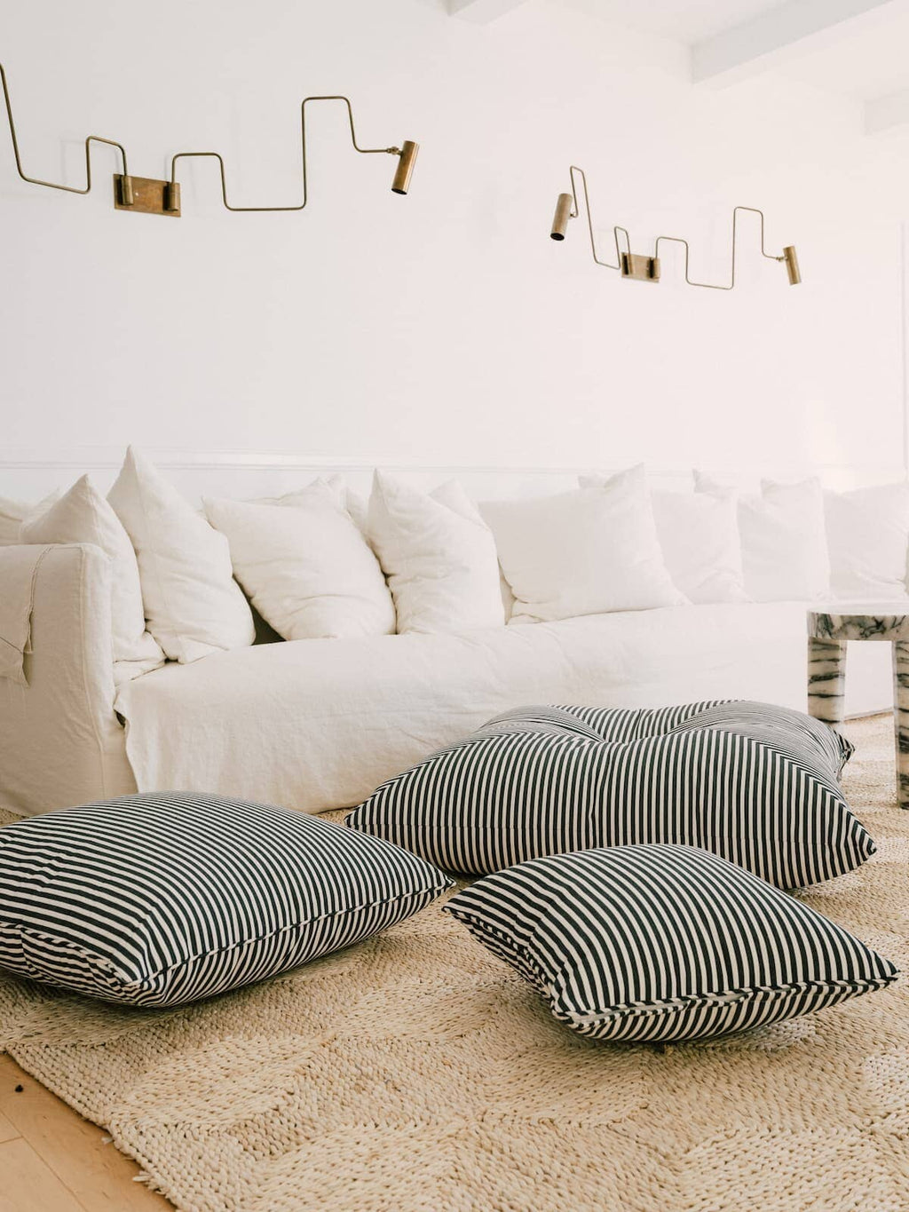 3 outdoor cushions scattered on a living room floor