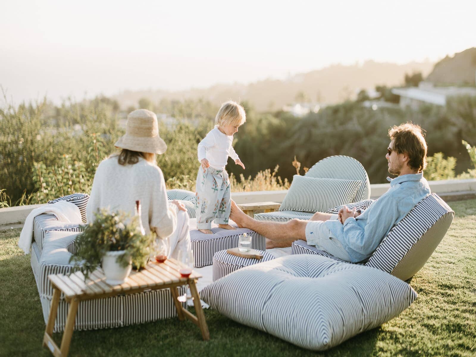 Family enjoying a picnic and sitting on the outdoor cushions and modular set