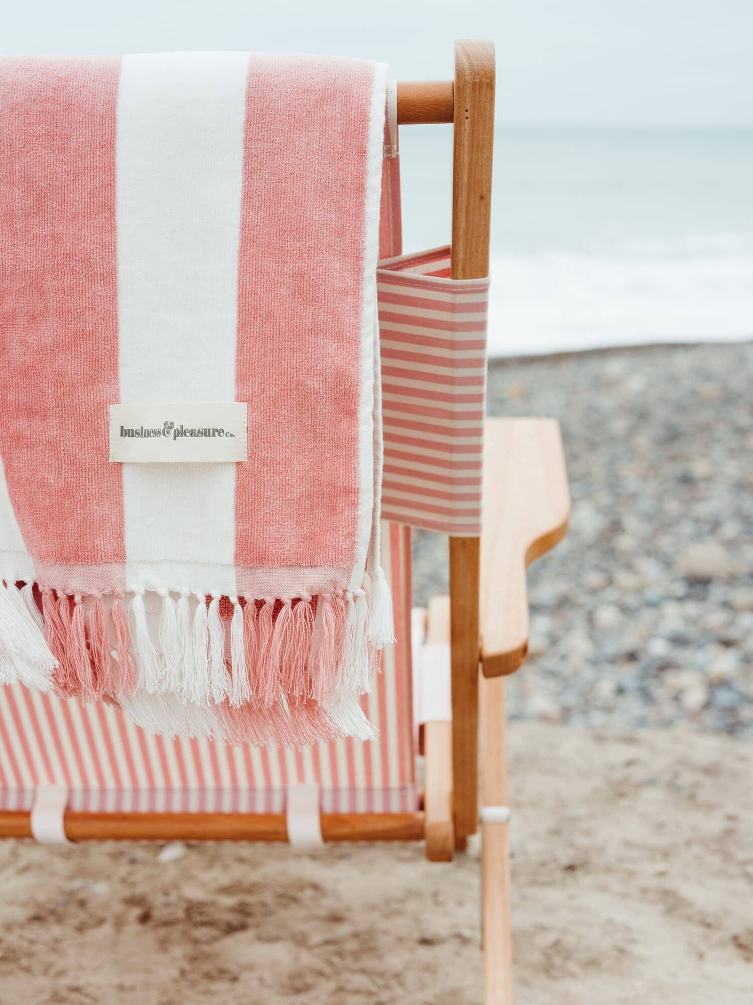 pink capri holiday beach towel hanging over back of beach chair