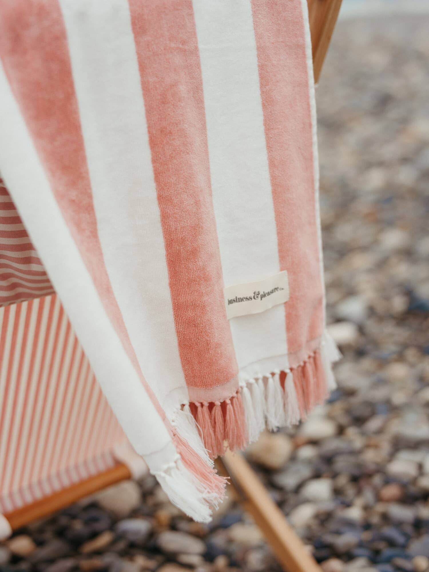 pink capri holiday beach towel hanging over back of beach chair