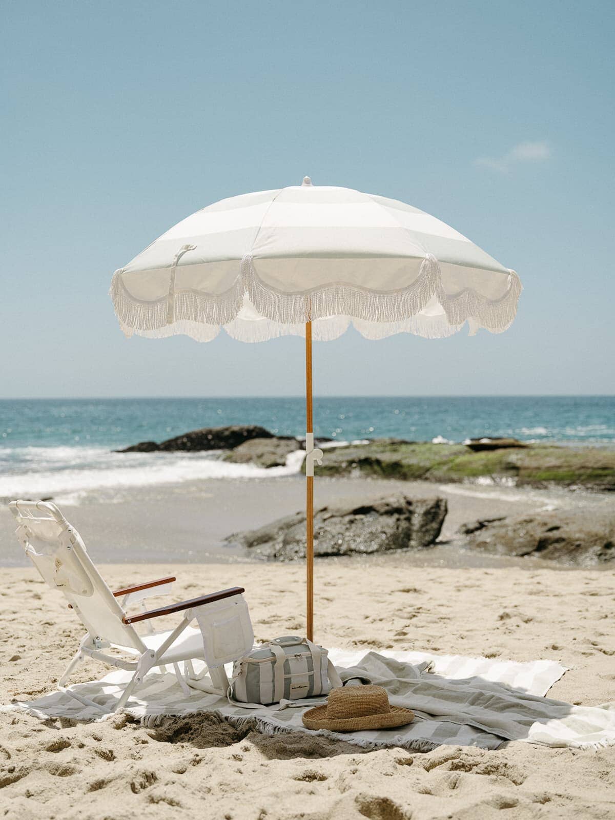 beach setting with sage stripe umbrella and blanket