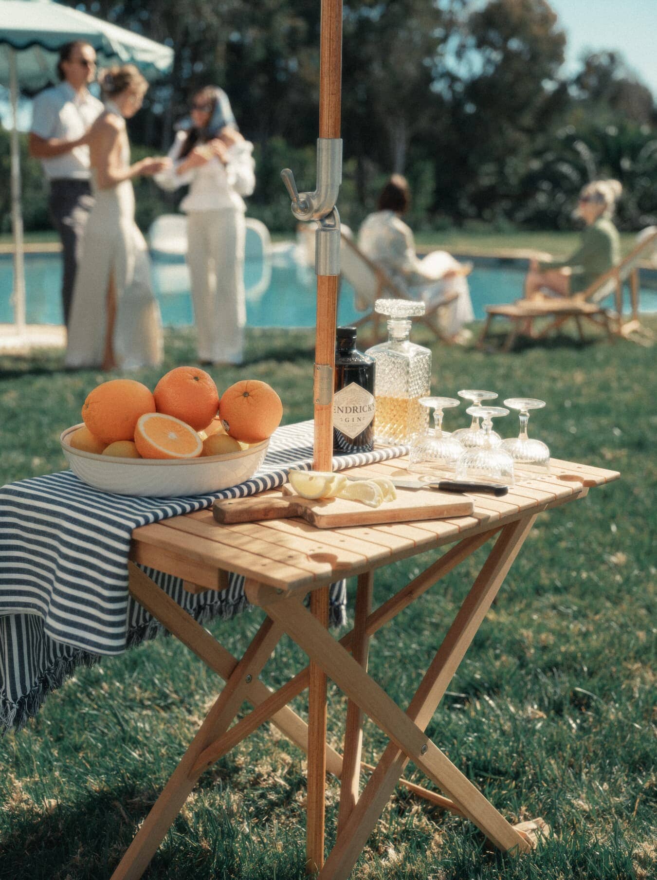 Outdoor picnic setting with tall folding table with drinks and fruit