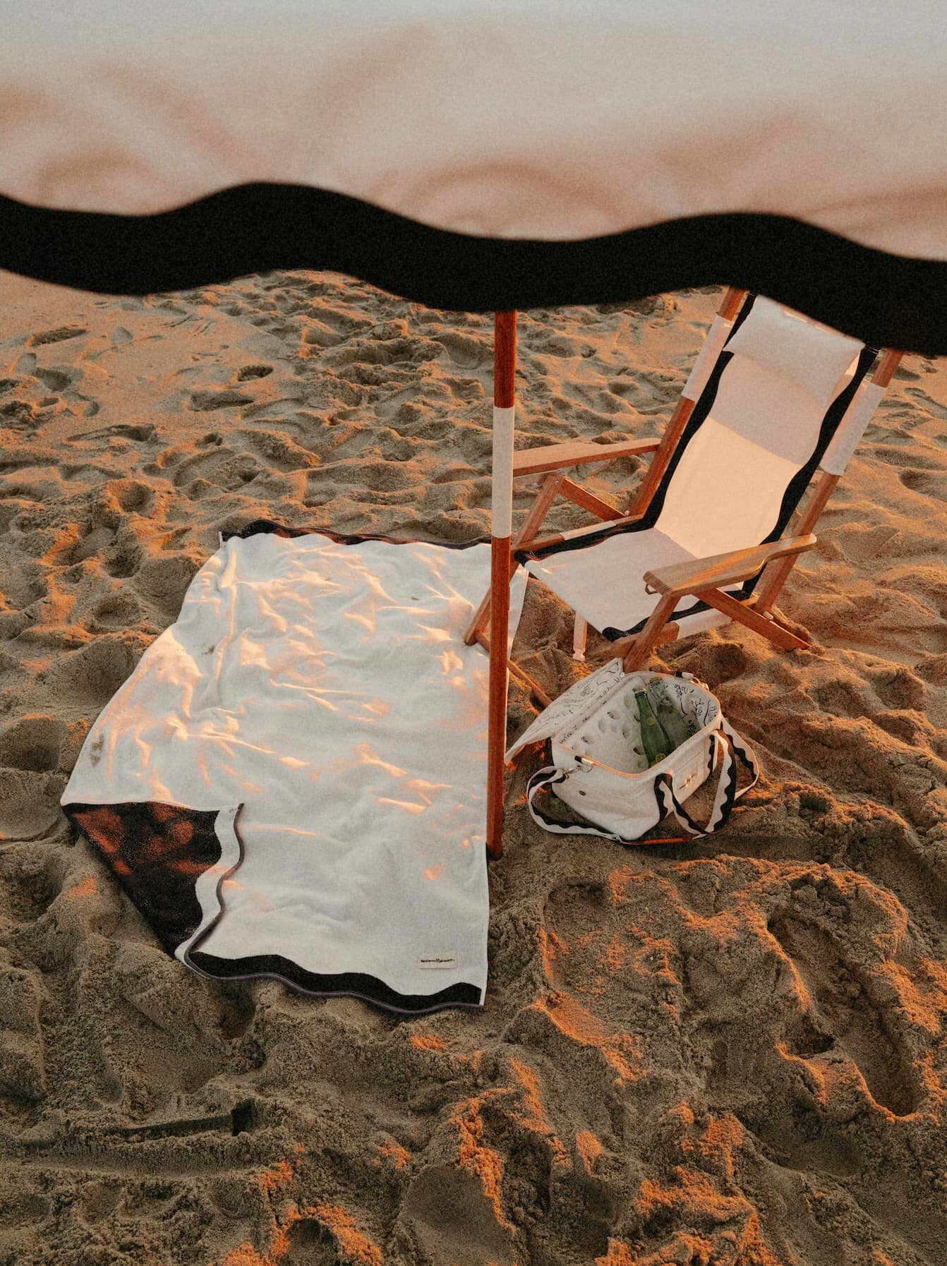 Beach setting with Riviera White umbrella, chair, towel & cooler