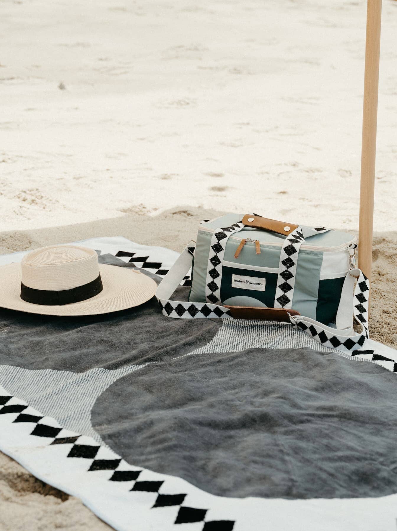 Diamond green beach towel, cooler bag and hat at the beach
